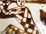 a brown and white plate with a drawing of a baseball player on it