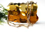 a gold purse with a chain around it and a flower