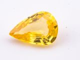 a yellow sapphire stone on a white surface