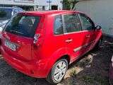 une petite voiture rouge garée sur un parking à côté d'autres voitures