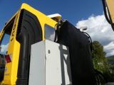 a yellow construction vehicle with a black and white refrigerator