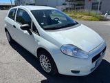 la petite voiture blanche est garée sur le bord de la route
