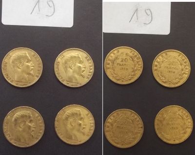 Plusieurs pièces d'or sont présentées sur une surface noire, accompagnées d'une étiquette indiquant leur prix.