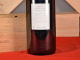 a bottle of wine sitting on a table next to a wooden box