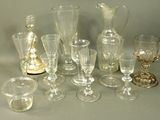 many glasses and vases sitting on a table