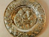 un plateau en argent orné d'un motif, posé sur une table