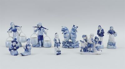 several blue and white figurines of people and animals on a white surface
