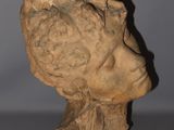 statue of a woman ' s head on a table with a gray background