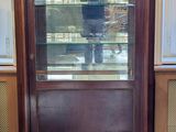 a man taking a picture of himself in the reflection of a glass case