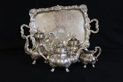 an antique silver tea set with a tray and a mirror