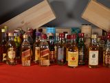 many bottles of alcohol lined up on a red table