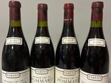 four bottles of wine are lined up on a table