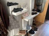 many pairs of shoes on a shelf in a room