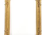 un cadre photo doré sur un mur blanc avec un fond blanc