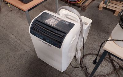 un petit climatiseur posé par terre dans un garage