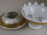 a white and gold vase and a bowl on a table