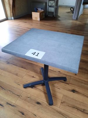 une petite table sur laquelle est inscrit un chiffre, posée sur un parquet
