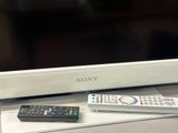 two remote controls sitting on a shelf next to a tv