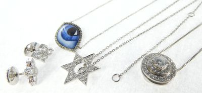 many different types of necklaces and earrings on a white surface