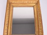 un miroir à cadre doré accroché à un mur blanc