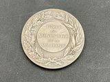 the coin is sitting on a black surface with a wreath around it