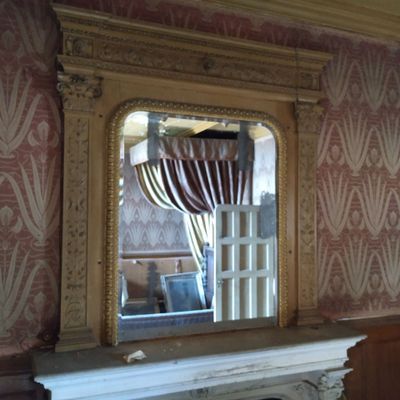 un miroir accroché au mur au-dessus de la cheminée d'une pièce