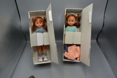 deux poupées qui se trouvent dans une boîte posée sur une table