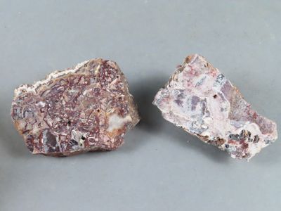deux morceaux de roche sur une surface grise, dont un au premier plan
