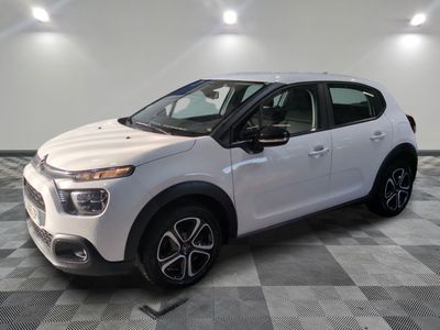 une voiture blanche est garée dans une pièce au sol à carreaux