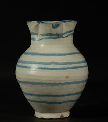 un vase rayé bleu et blanc posé sur une table
