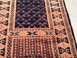 an image of a black and orange rug on a white floor