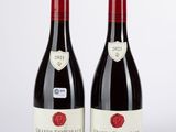deux bouteilles de vin rouge posées l'une à côté de l'autre sur une table