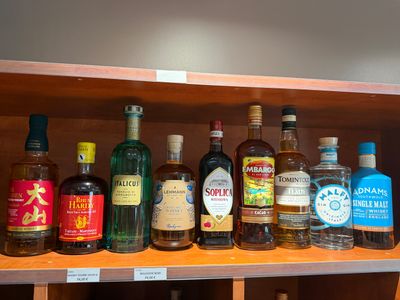 de nombreuses bouteilles d'alcool sur une étagère dans une pièce
