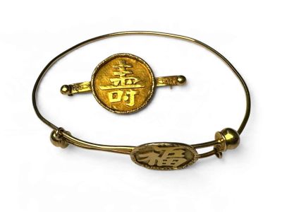 un gros plan d'un bracelet orné d'une pièce d'or