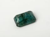 a close up of a green emerald stone on a white surface