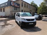 une petite camionnette blanche garée devant un bâtiment