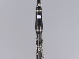 a close up of a clarinet on a clear surface with a gray background