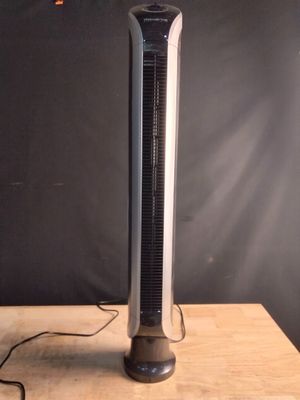 a black and silver tower fan sitting on a wooden table