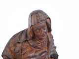 a statue of an old woman sitting on a bench