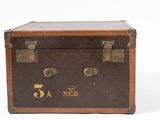 a brown suitcase with a gold logo on it