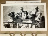 a black and white photo of a group of men on a boat