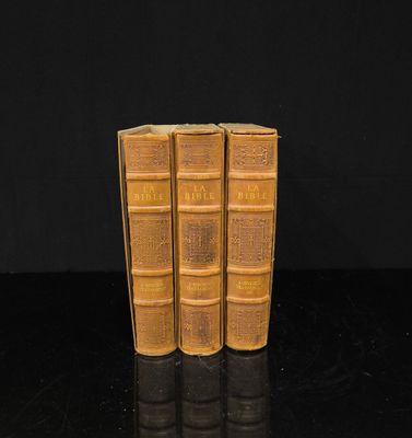 trois vieux livres posés les uns à côté des autres sur une table noire