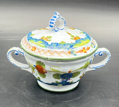 a white and blue bowl with a lid on a table