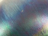 a close up of a metal object with a blue and green pate