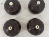four black wooden knobs with brass numbers on them on a white surface