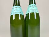 two bottles of wine sitting on top of a table next to each other