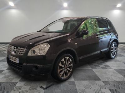 La voiture marron est garée dans le garage, sur le sol à carreaux.