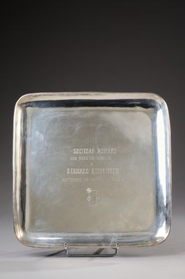an antique silver plate with a metal handle on a metal stand