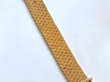 un gros plan d'un bracelet de montre sur une surface blanche