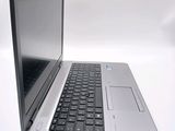 a silver laptop with a black keyboard on a white surface